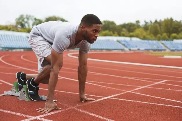 A person is in ready to run position wearing a summer sports t-shirt fabric